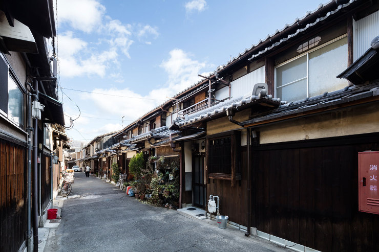 狭い道路の両側に瓦屋根の軒が連なる。戦前から続く町並み。